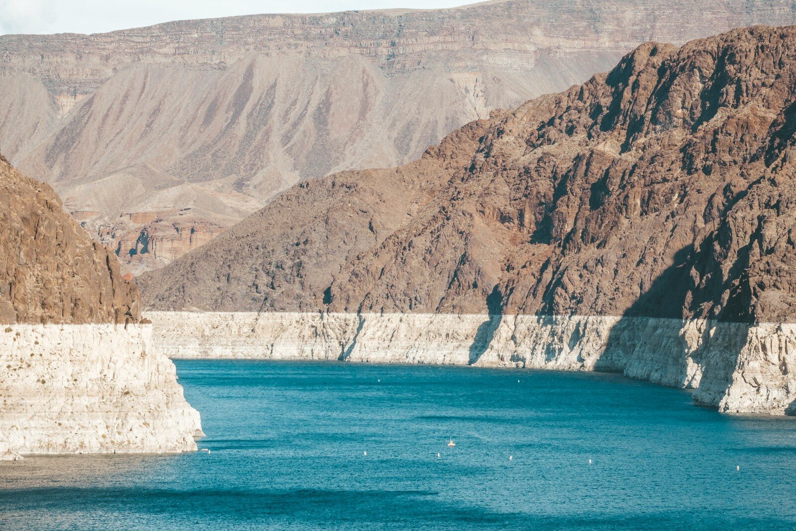 gray mountain beside body of water during daytime